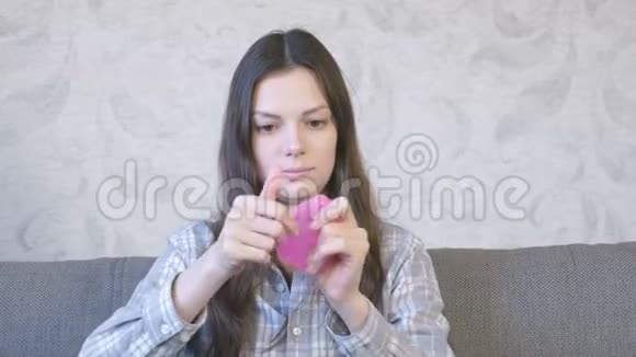 女人正在伸展一个粉红色的黏液坐在教练上玩从黏液里看过去视频的预览图