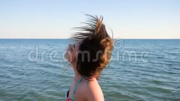 长头发的女孩沿着海岸奔跑苗条的女孩缓慢地奔跑视频的预览图