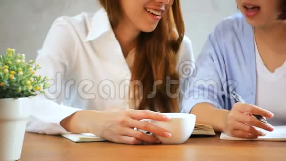 女商人用手机在木桌上写报告亚洲女人用电话和咖啡视频的预览图