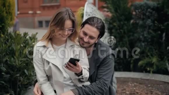 在大学附近的城市里一对可爱的年轻漂亮夫妇在一起学习和玩后坐在地上视频的预览图