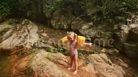 河边湿石上的小女孩视频的预览图
