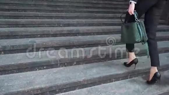 商务女性穿着正式西装走上室外楼梯的下部视频的预览图