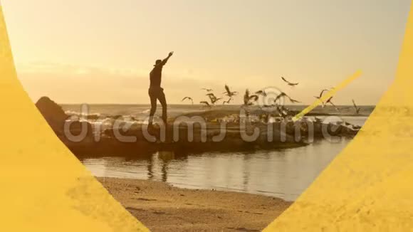 男人在沙滩上挥舞着手臂穿过黄色的心形前景视频的预览图