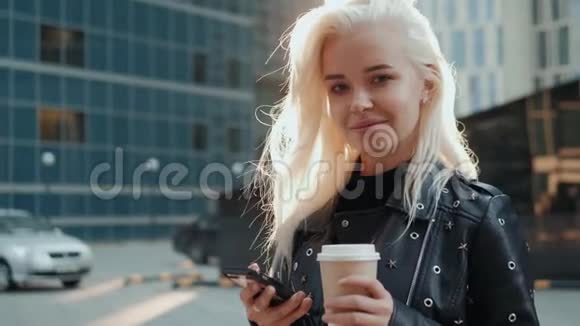 一位年轻时尚的女士在城市街道上的日落咖啡电话视频的预览图