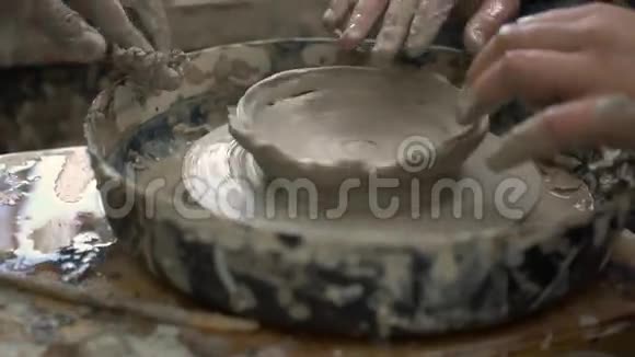 波特和青少年试图在一个车间的陶轮上做一个陶瓷碗视频的预览图
