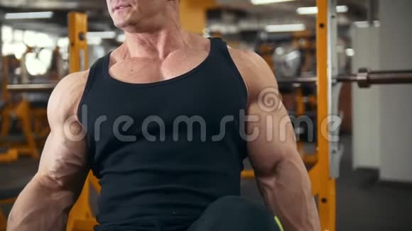 健身房举重年轻肌肉男用哑铃训练二头肌视频的预览图