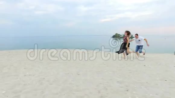 美丽的女孩和她的男朋友在海滨玩耍那个男人多甘亚特女孩吻了她视频的预览图