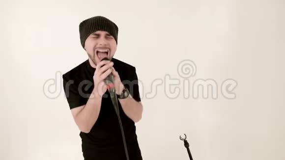 前台歌手摇滚流行乐留着时髦的黑胡子戴着帽子手里拿着麦克风视频的预览图