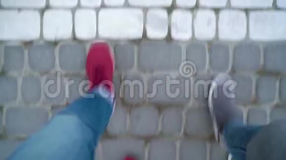 在人行道上漫步的男女双腿的俯视图视频的预览图