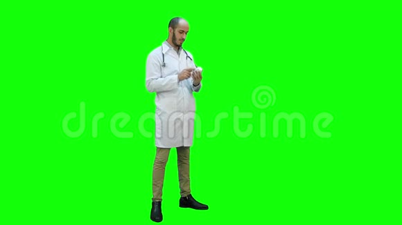 男医生仔细阅读标签上的一瓶药丸上的绿色屏幕铬键视频的预览图