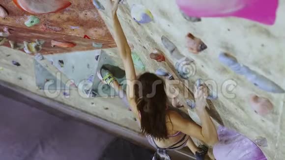 年轻女子攀岩者正在室内攀岩馆攀岩身材苗条的美女使出浑身解数视频的预览图