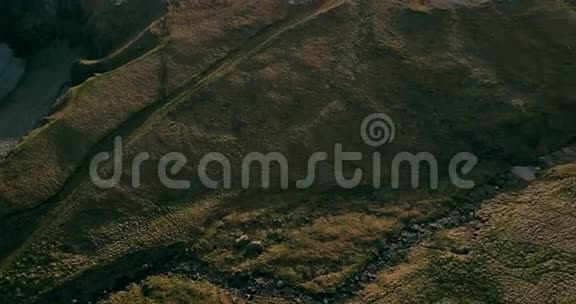 鸟瞰野河在山谷中流动直升机飞过绿色的田野冰岛的熔岩山视频的预览图