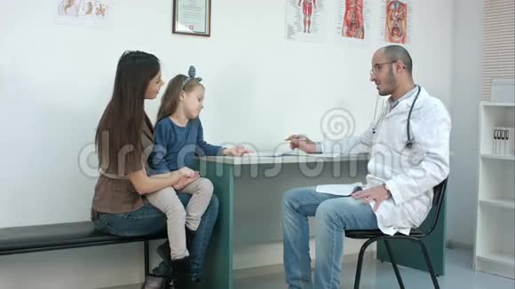 儿科医生填写医疗表格母亲带着小女儿描述他们的问题视频的预览图