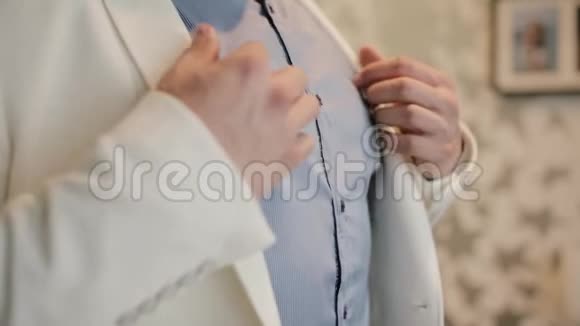 秀曼准备工作穿上他的白色西装近景男手穿夹克穿衣服视频的预览图