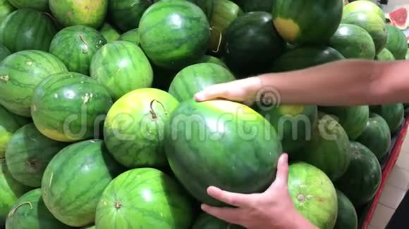男人在农民超市挑选新鲜的有机西瓜视频的预览图