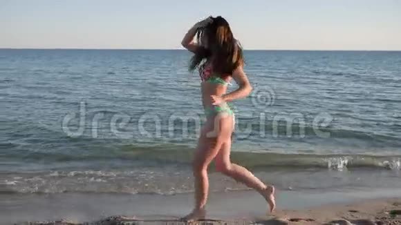 美丽的身材在沙滩上奔跑的模特头发发育视频的预览图