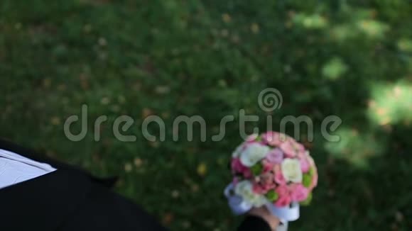 新郎举起手中的结婚花束美丽的婚礼花束鲜花视频的预览图