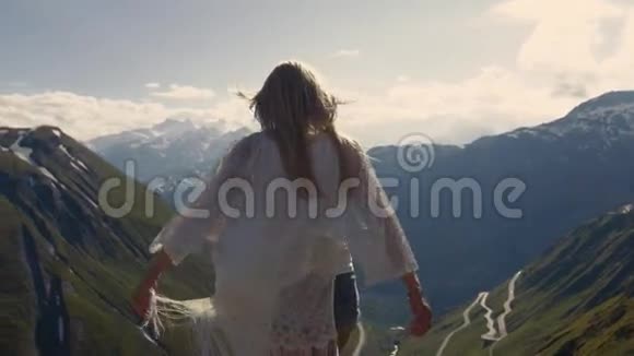 迷人的女孩在世界之巅随风嬉戏大山背景上视频的预览图