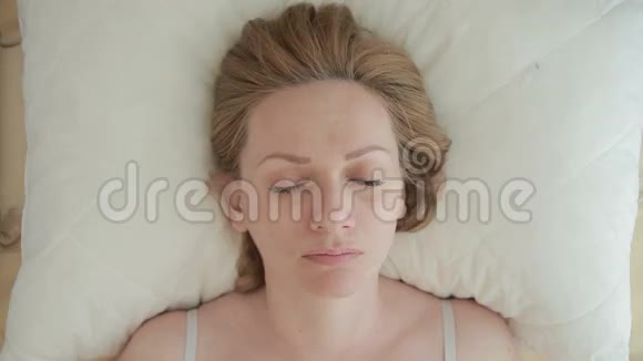 一个女人躺在床上猛地睁开眼睛看着镜头特写镜头从上面看视频的预览图