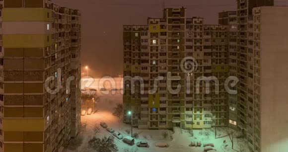 城市里的暴风雪晚上从窗口到庭院的景色视频的预览图