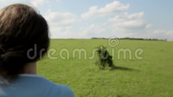 快乐的女孩赤脚跑在绿草上视频的预览图