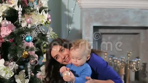 圣诞假期快乐的妈妈和小儿子在家玩视频的预览图