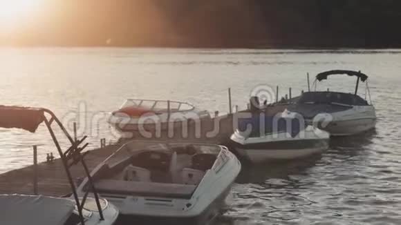 傍晚时分在海岸附近有一艘摩托艇停泊在老木船上快船站在码头附近视频的预览图