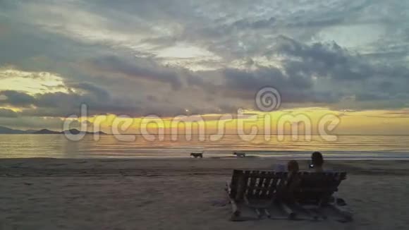 在无边无际的大海上在独特的黎明海滩上的一对情侣视频的预览图