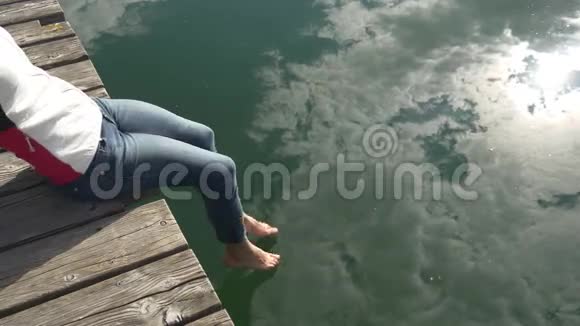 云在清澈的水面上倒影着女人的脚视频的预览图