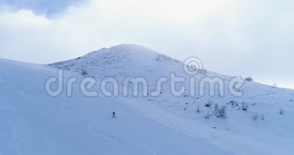 侧航越冬雪山滑雪田径场登山滑雪者走上登山白雪覆盖视频的预览图