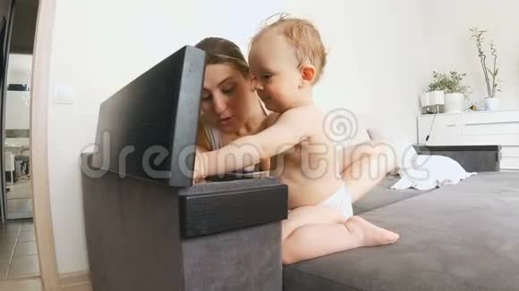 可爱的小男孩和妈妈坐在沙发上探索床头柜视频的预览图