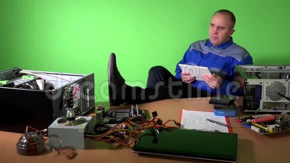 粗心的工程师腿在桌子上玩平板电脑视频的预览图