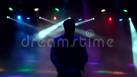 一个现代的年轻人在夜总会的黑暗中跳舞视频的预览图