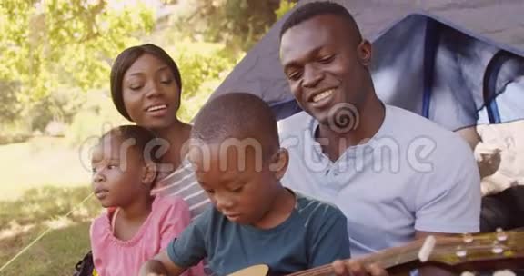 父亲在帐篷前和家人弹吉他视频的预览图