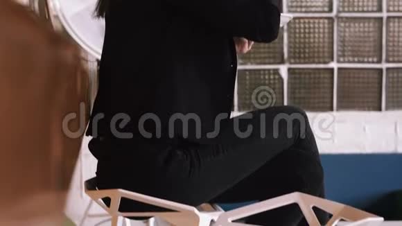 漂亮的年轻商务女性在酒吧柜台背景的咖啡馆里用勺子吃蛋糕视频的预览图