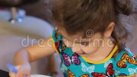 小女孩贪婪地吃着半月粥用水从透明玻璃中洗下来特写镜头视频的预览图