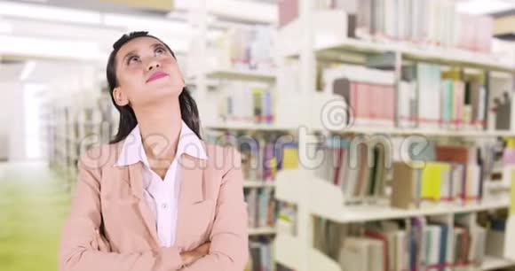 站在图书馆思考的女人视频的预览图