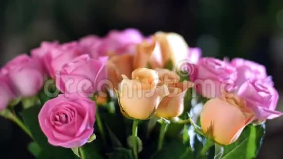 特写花束在光线的照射下旋转花的组成由粉红色和橙色的玫瑰水组成视频的预览图