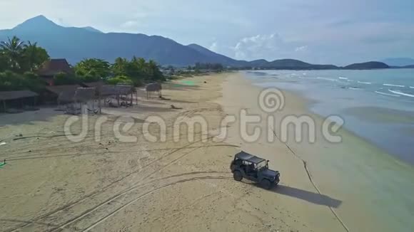从军用吉普车起飞的飞行摄像头站在海滩到海边视频的预览图