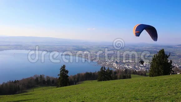 在晴朗的天气和晴朗的蓝天下滑翔伞飞越祖格市祖格西和瑞士阿尔卑斯山视频的预览图