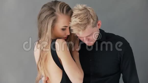 优雅的一对夫妇笑着拿着相机手挽手在灰色背景下视频的预览图