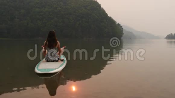 女人在桨板上冥想视频的预览图