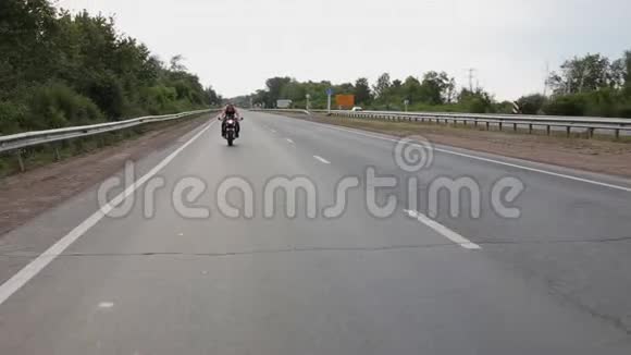 肌肉男沿着马路骑摩托车视频的预览图