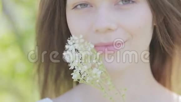 年轻漂亮的女人有白色的草甸花特写视频的预览图