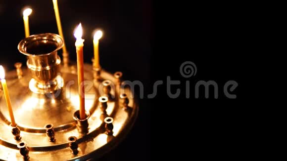 在基督教东正教教堂黑暗的背景下点燃蜡烛把黄金隔离在祭坛上视频的预览图
