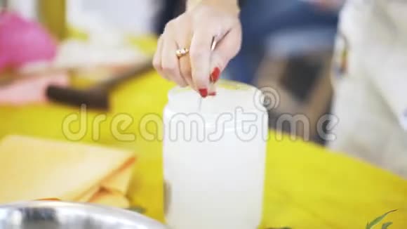 关上一个女人搅拌白色混合物作为分子厨房产品视频的预览图