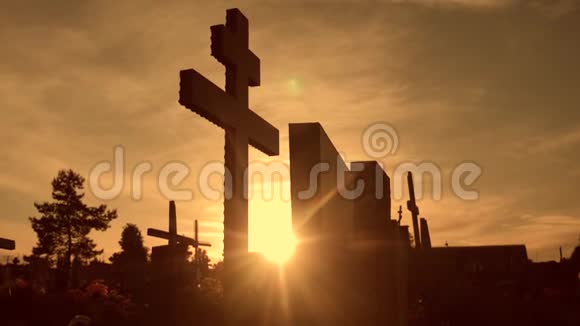 死亡生命的概念在日落十字剪影中墓地穿过阳光从墓地后面的生活方式中闪烁出来视频的预览图