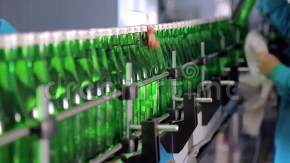 这条生产线的一名员工擦拭矿泉水用的绿色玻璃瓶视频的预览图