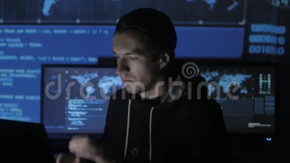 男性极客黑客在电脑上工作过度在充满显示器的网络安全中心头痛视频的预览图