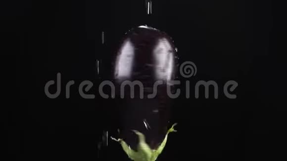 茄子特写水滴落在黑色背景上旋转的苹果上超级慢动作视频的预览图